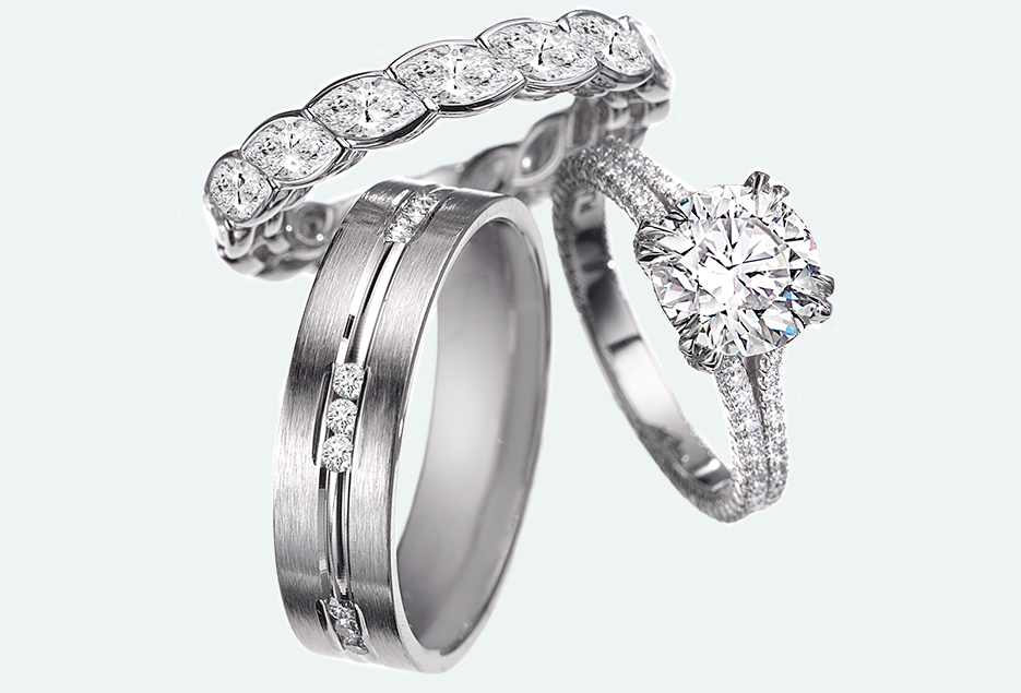 Group setting of a circle four prong halo cut engagement ring and diamond wedding bands.